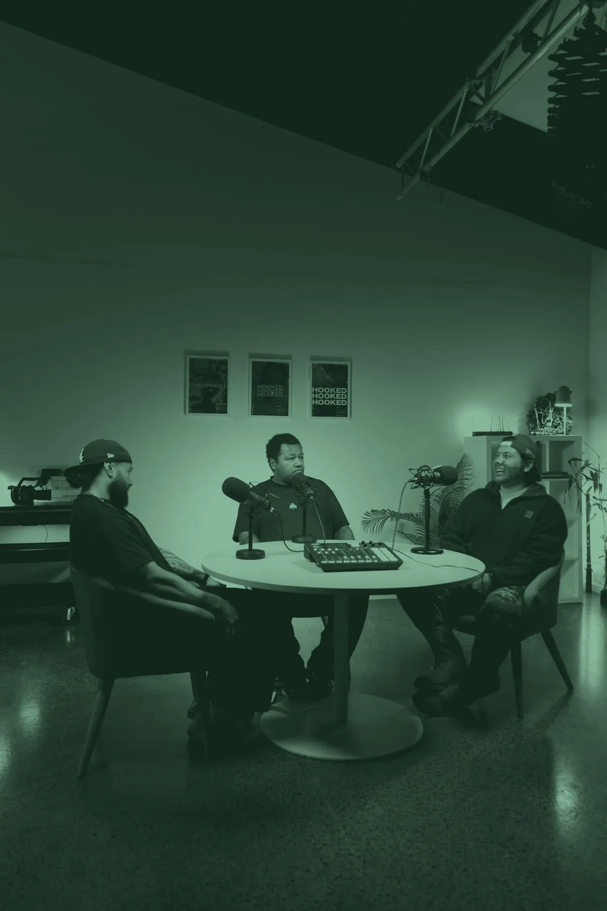 The full Hooked studio set, three around the table recording — Montel Tivoli on the left.